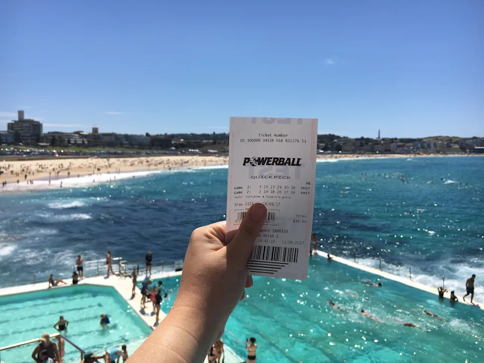 A picture of a Powerball ticket in front of Bondi Beach.