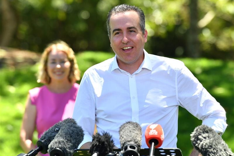 A man in a white shirt in front of microphones