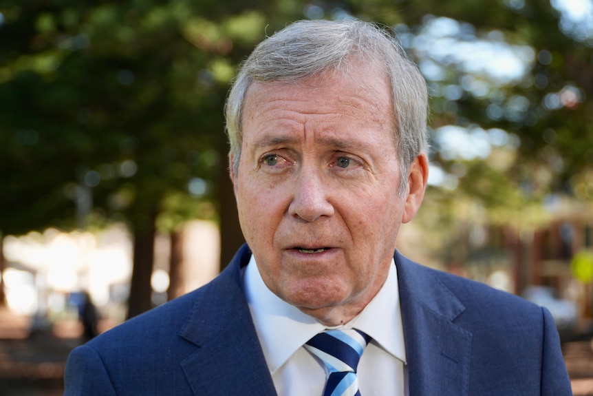 A man in a suit listens intently