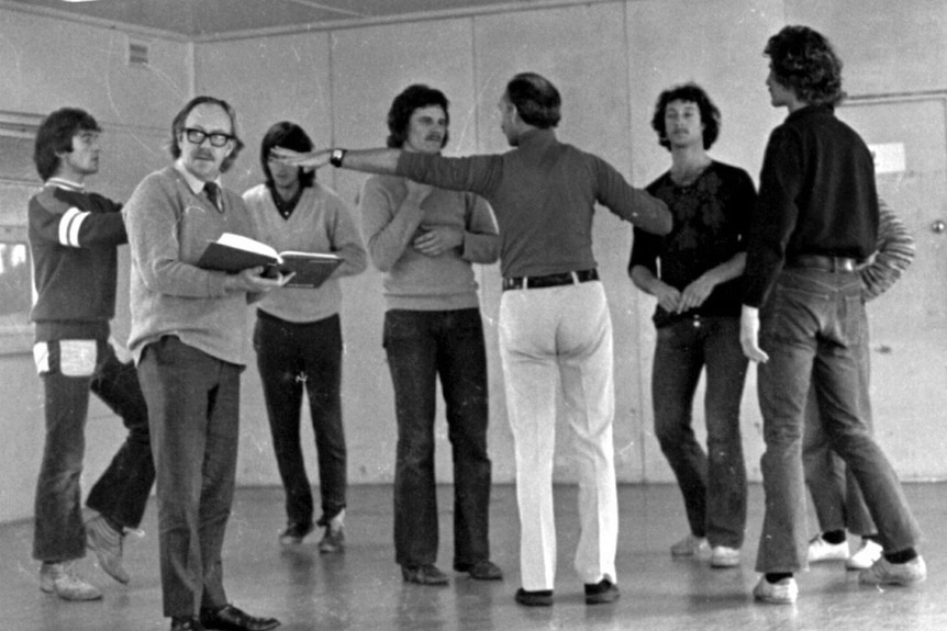 A group of male performers rehearsing.