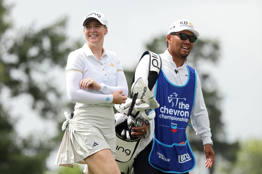 Golfer Cassie Porter smiles alongside her caddie at the Chevron Championship.