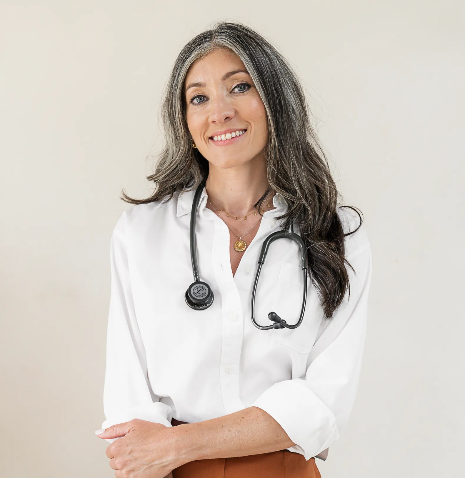 Dr. Lafina Diamandis, wearing a white shirt and a stethoscope, smiles at the camera.