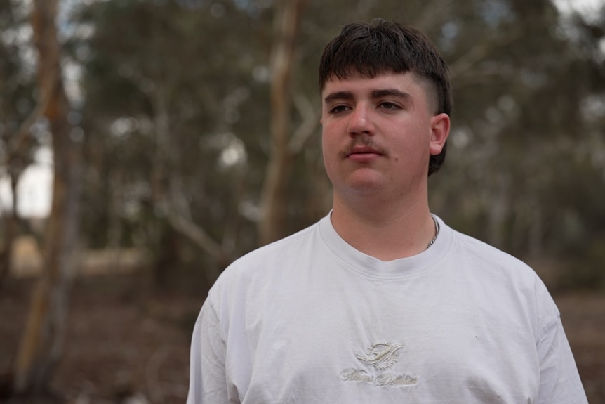 A young man looks to the side. 