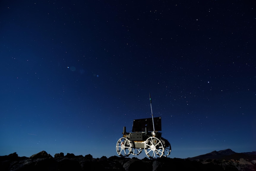 A moon rover with a night sky background.