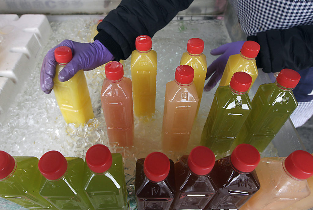 Bottled juice are arranged at a fruit stall in a traditional market in Taipei