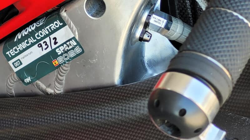 Scoop photo of Márquez’s GP26 with cutouts (usually hidden by carbon-fibre covers) behind the steering head to provide lateral flex. The hydraulic hose suggests the frame doubles as an oil catch tank