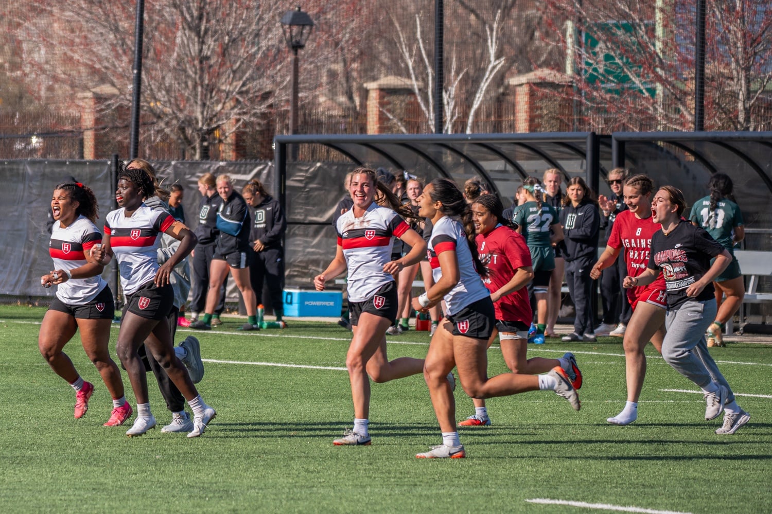 The Harvard rugby team rushes the field after winning Ivy 7s. 