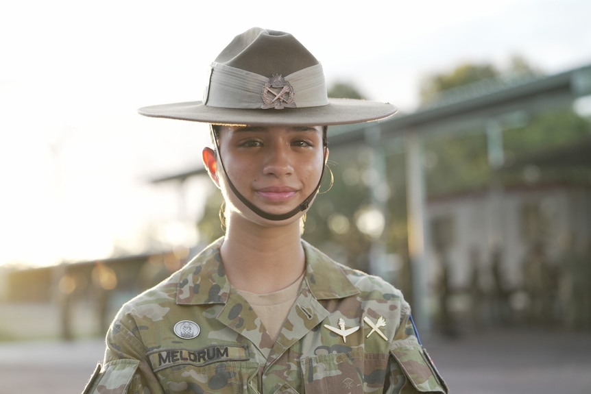 Female army officer in uniform with a hat and chin strap. 