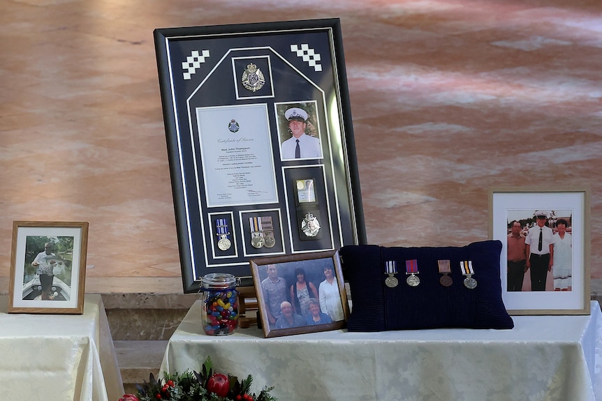 Photos of a fallen police officer on a display table at his funeral