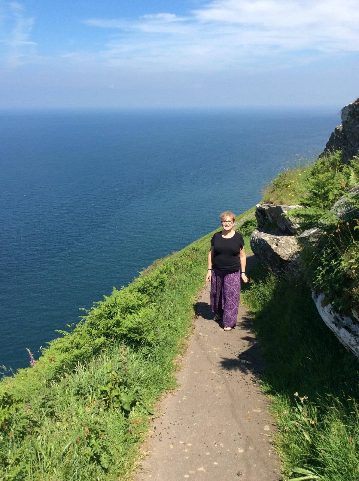 Woman walking along a coastal path
