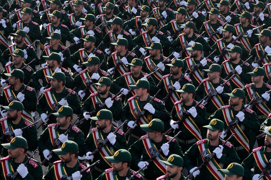 Iranian Revolutionary Guard cadets march in uniform with rifles during an annual military parade.