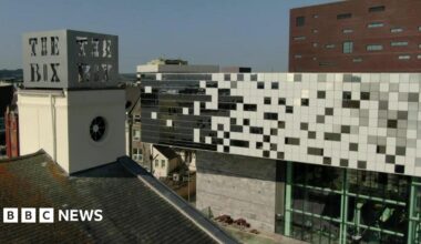 An aerial shot of the Box museum and art gallery in Plymouth taken on a clear sunny day. The words 'The Box' are visible on top of one of the buildings while the main large builder is in the background with big glass windows.