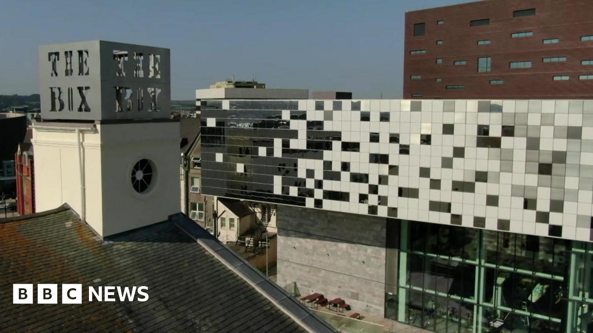 An aerial shot of the Box museum and art gallery in Plymouth taken on a clear sunny day. The words 'The Box' are visible on top of one of the buildings while the main large builder is in the background with big glass windows.