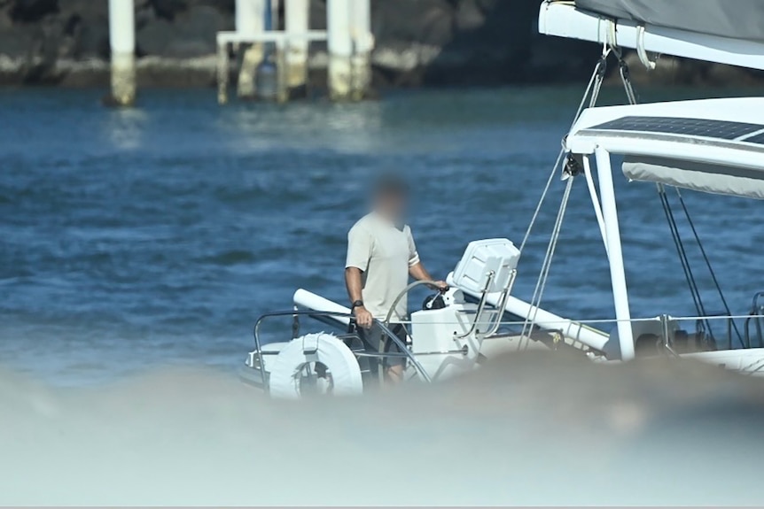 A man in a boat with his face blurred.
