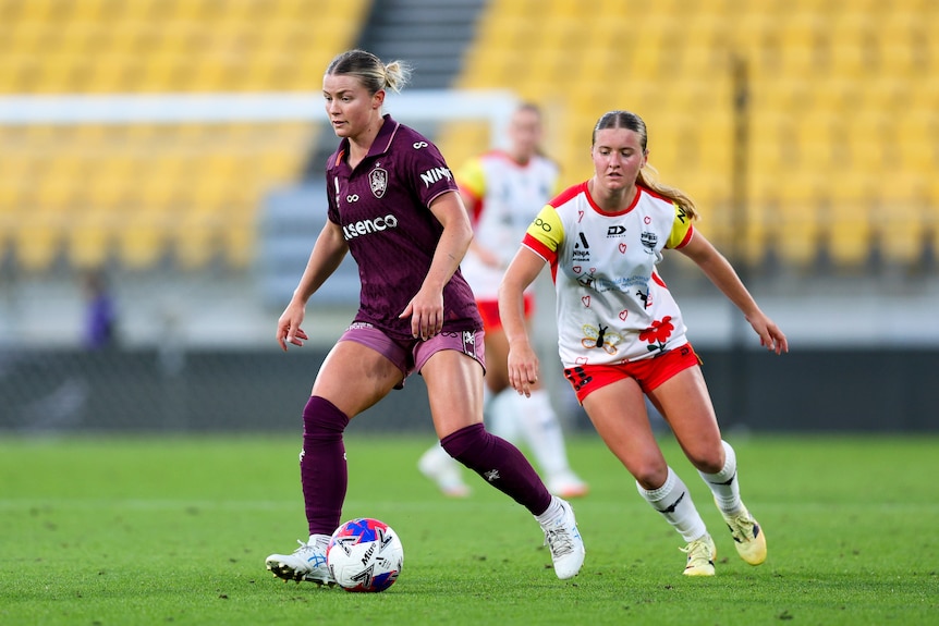 Aimee Medwin of the Roar attempts to evade Manaia Elliott of the Phoenix.