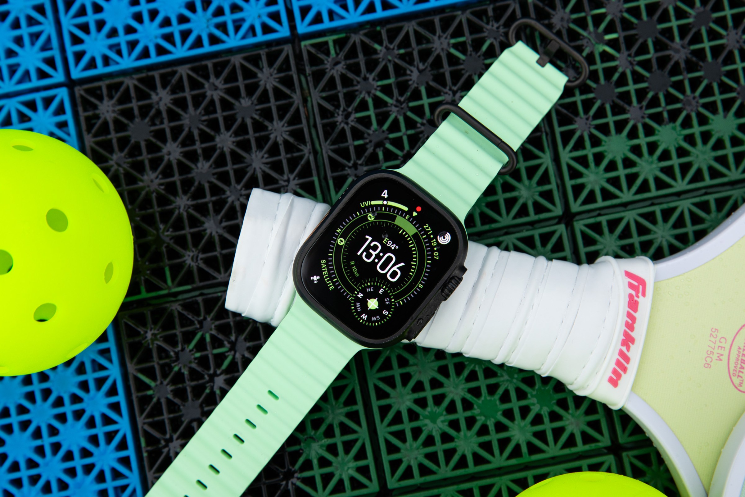 Close up of the Apple Watch Ultra 3 on top of a pickleball racket and court.