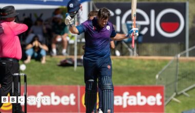 George Munsey raises his bat after reaching three figures