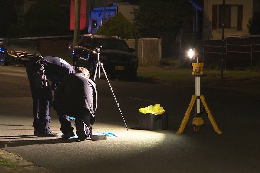 Forensic officers scour for evidence at the scene of a shooting.