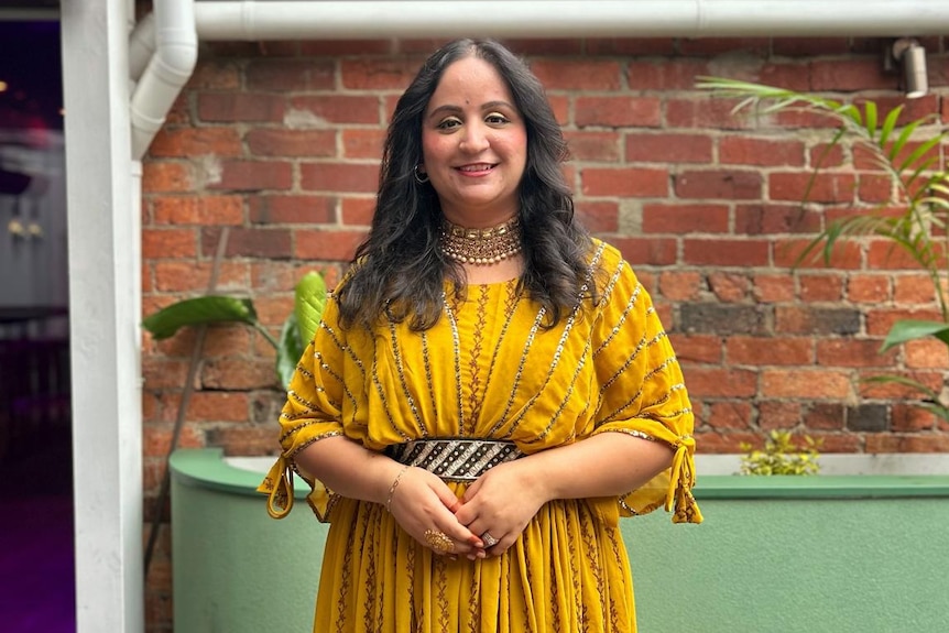 Mrinaal Datt wearing a yellow dress, standing outside