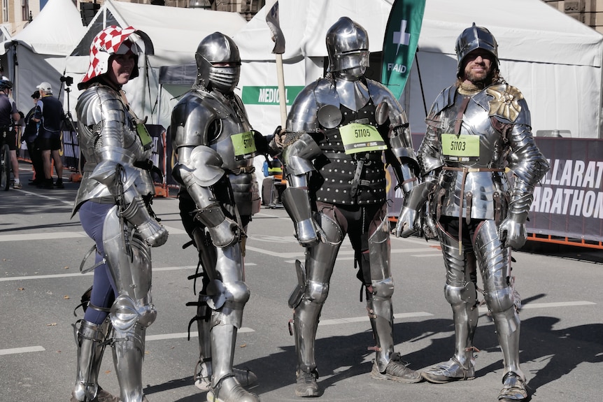 Four people in medieval armour pose