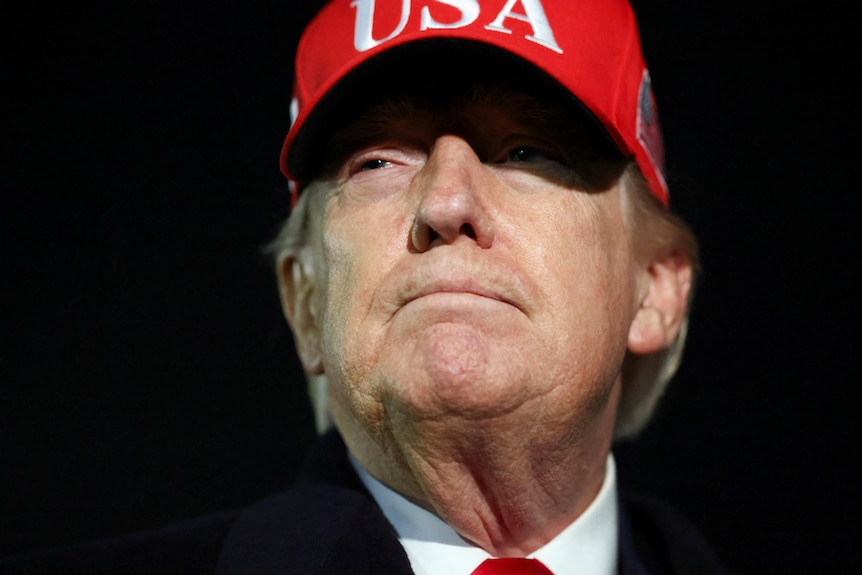 A close-up shot of a man with a red cap