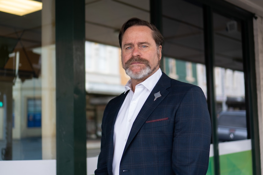 Peter Whish-Wilson wearing a suit on the street outside a Greens office.