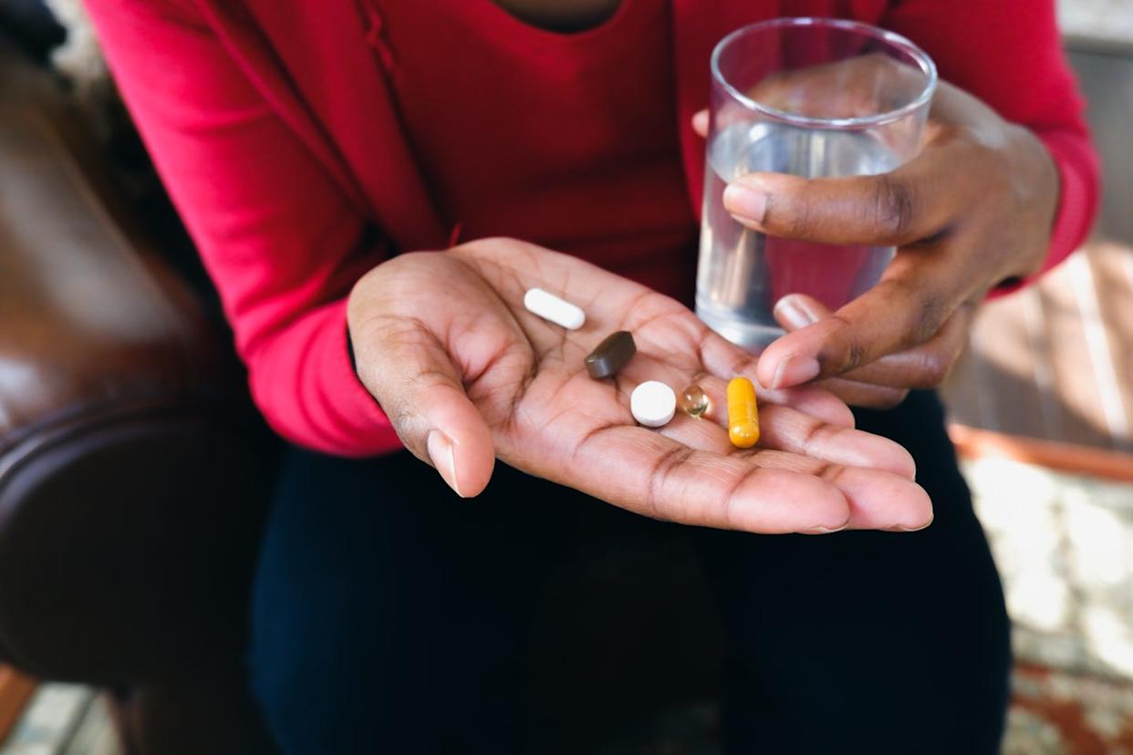Woman Holds Pills in Palm of Hand