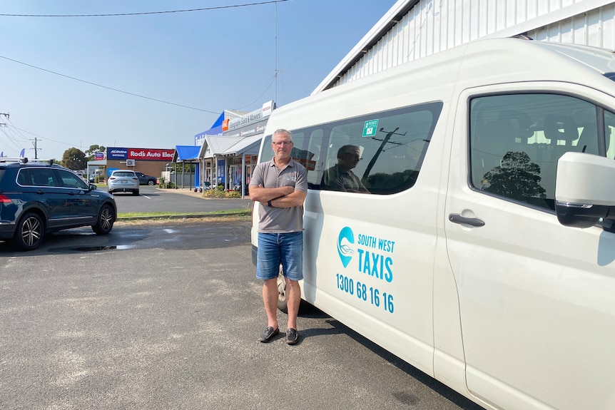 A man on the right of screen standing in front of white van