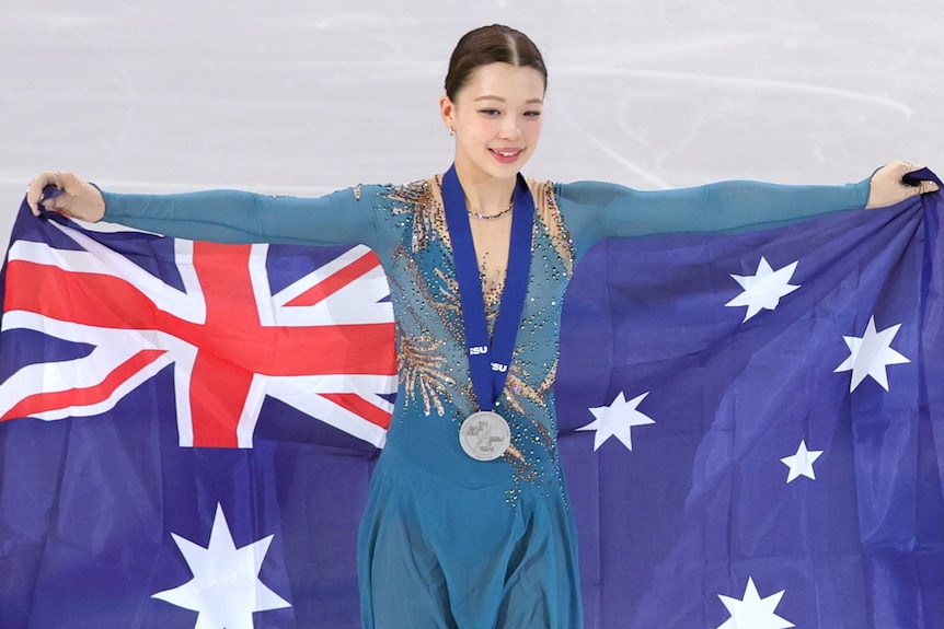 Hana Bath holds the Australian flag while wearing her silver medal