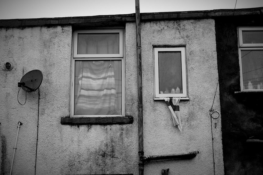 Sheets of fabric being used as curtains behind windows.