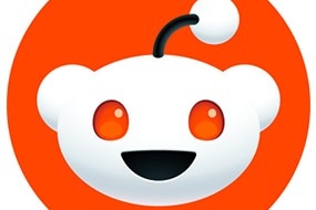 A red speech bubble below a white, teddy-bear-like alien face with a single antenna on its head.