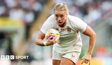 Alex Matthews runs with her body bent slightly forward and a rugby ball tucked to her chest under her right arm as she looks ahead during a World Cup match for England in 2025