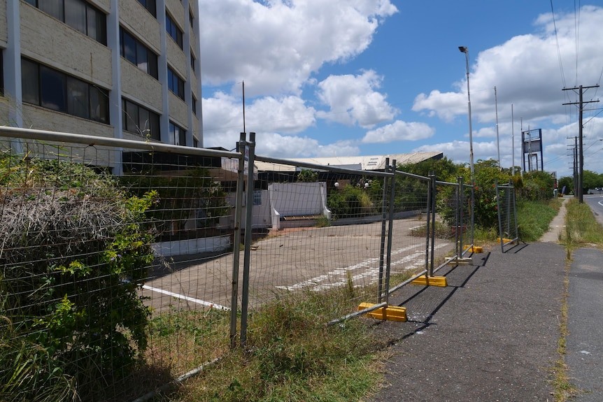 Temporary fencing in front of an abandoned hotel.