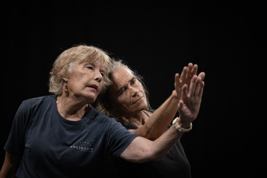 Two women dancing together their heads and hands are together.