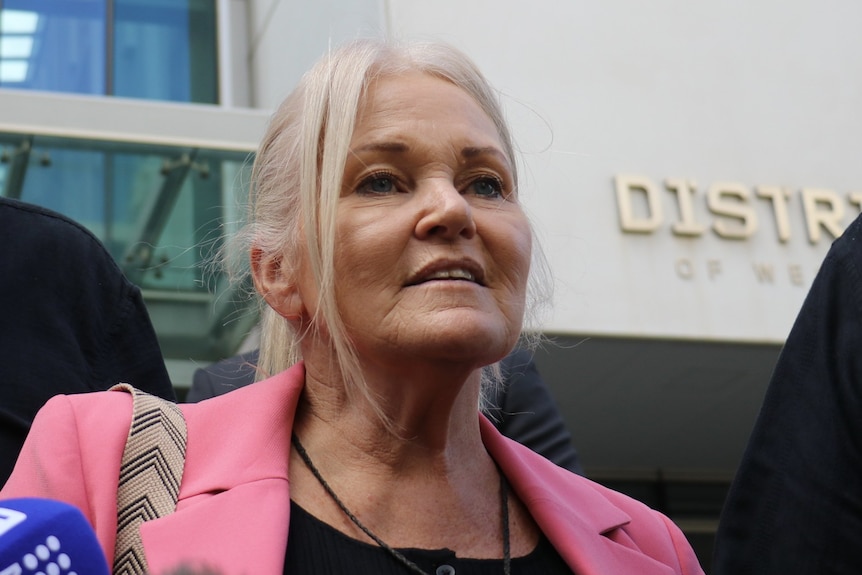 Susan T'Hart, wearing a pink blazer, speaks outside the WA District Court. 