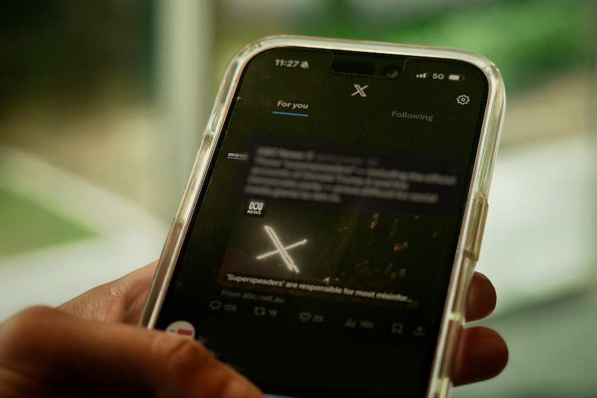 A person scrolling social media platform X on their mobile.