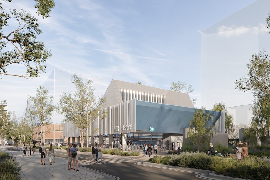 A light grey building with 'The Bays' written on it with some vegetation around it.