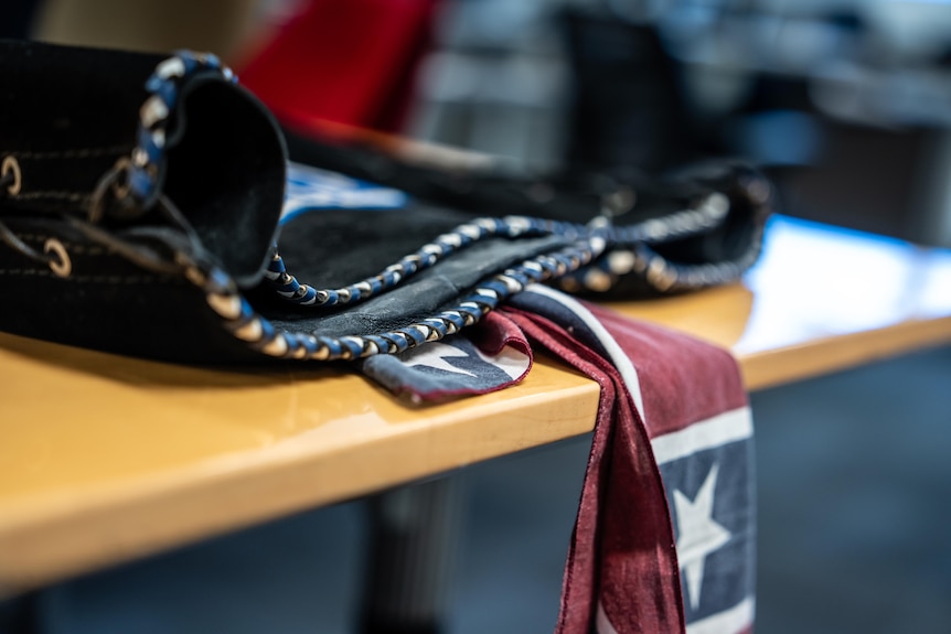 A biker vest and a flag on a table.