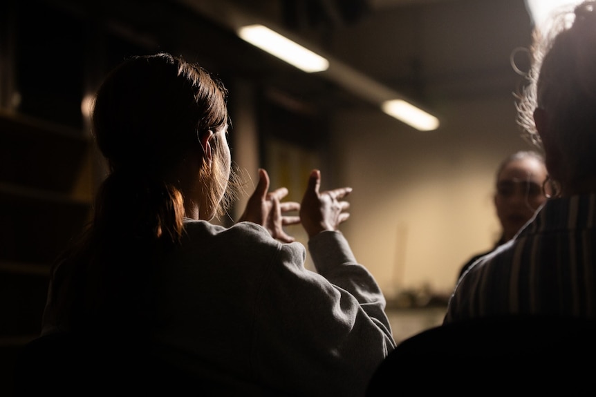 A girl is shown gesturing to a reporter