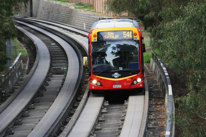 A red bus on a concrete track