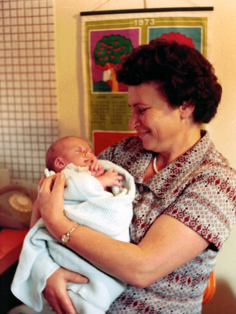A grandmother holds her baby grandson.
