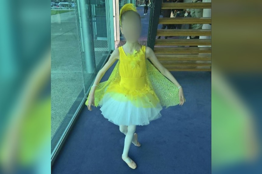 A picture of a girl in a yellow and white tutu posing.