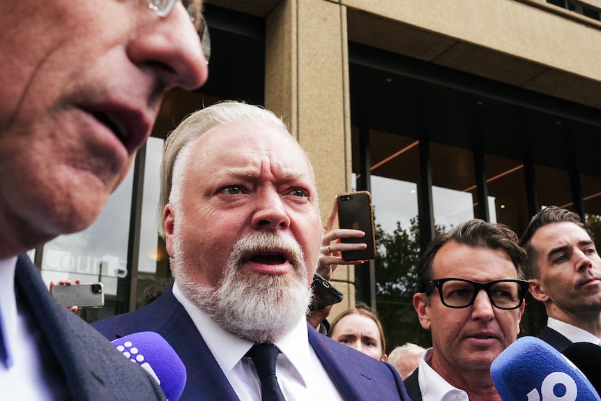 Kyle Sandilands arrives at court surrounded by media.