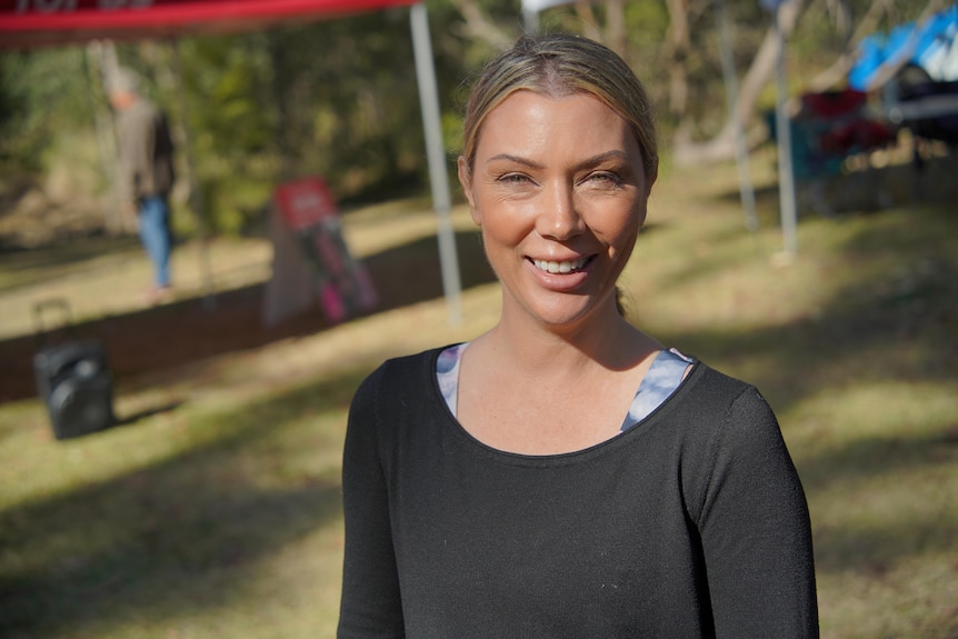 A woman standing next to a running tracks. 