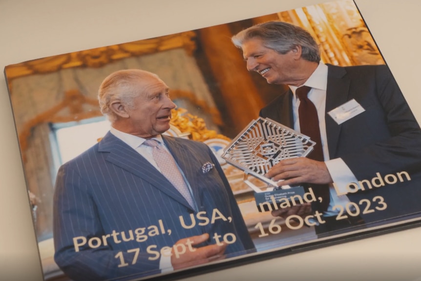 A book with a man being given an award by King Charles on the cover.
