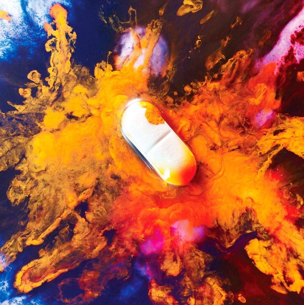 A capsule surrounded by vibrant colors and swirling patterns.