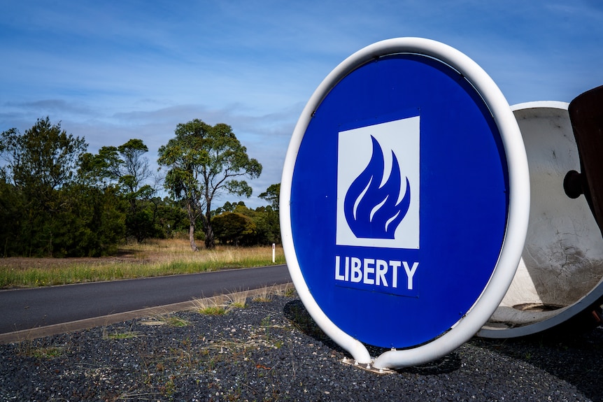 A blue sign with a flame on it and the word 'LIBERTY' underneath, on the side of the road.