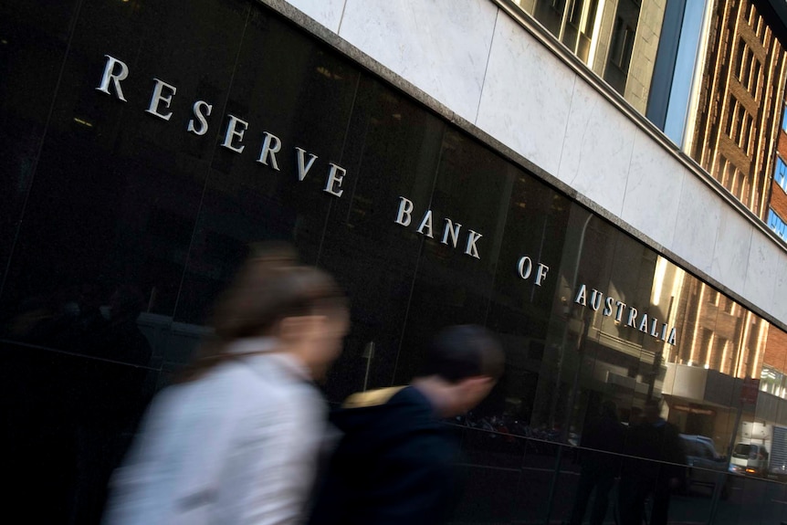 People walk post the Reserve Bank of Australia's building.