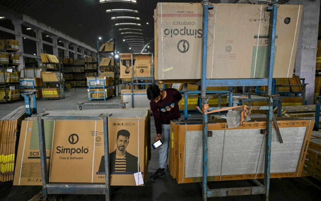 A worker scans tiles at a ceramics factory facing propane shortages, in the Indian city of Morbi: Blazing-hot kilns employing hundreds of thousands of people have gone cold, shut down in an energy crunch sparked by the US-Israeli strikes on Iran.