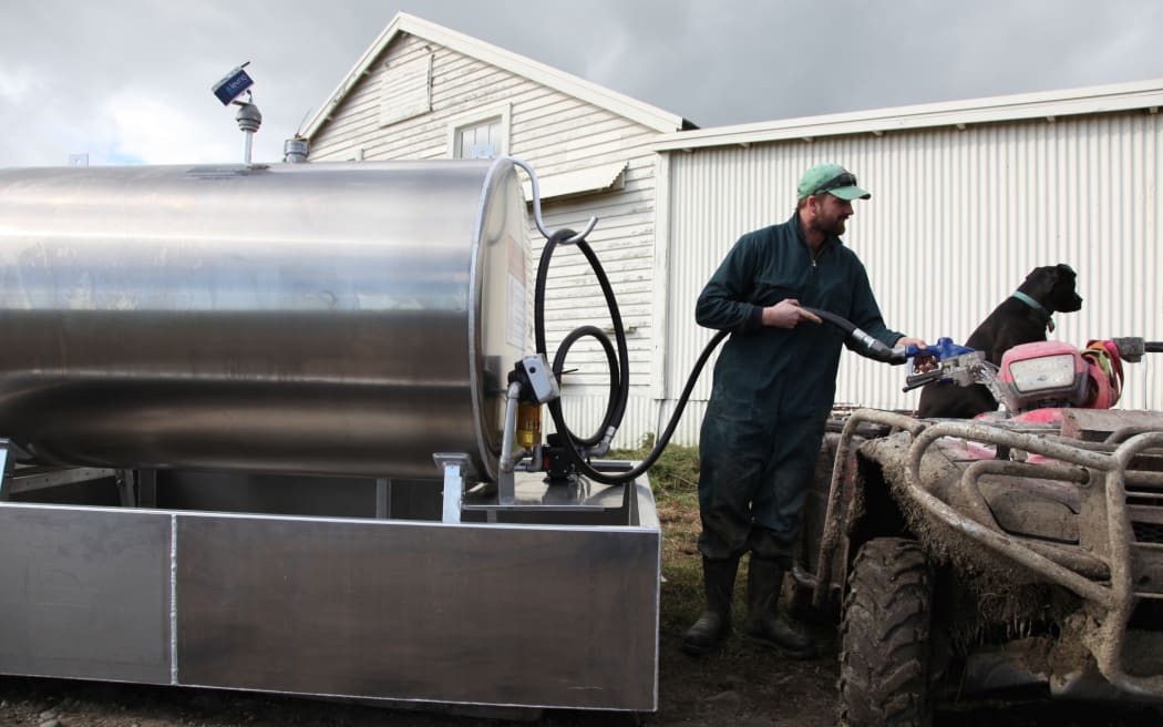 A farmer with his farm fuel tank featuring Levno sensors to monitor fuel withdrawals.
